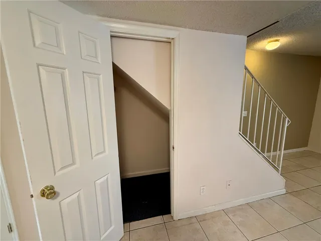 This interior offers a practical layout with a door leading to a storage space beneath the stairs.