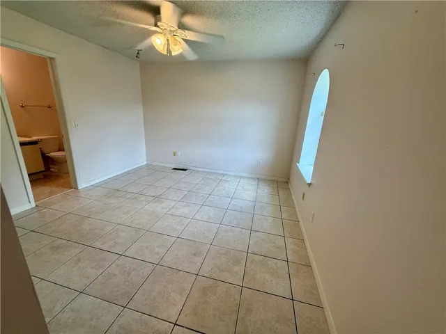 This versatile space offers potential for various uses, featuring durable tile flooring and soft natural light.