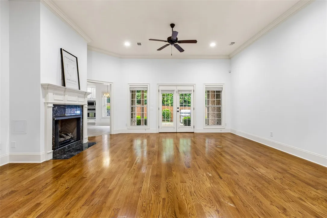 This bright living area features a classic fireplace, warm wood flooring, and abundant natural light.