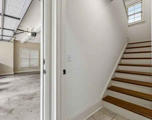 This spacious garage and elegant staircase offer both utility and charm.