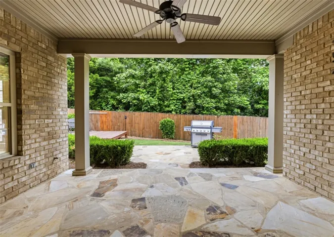This inviting covered patio offers an exceptional outdoor living space perfect for relaxation and entertaining.