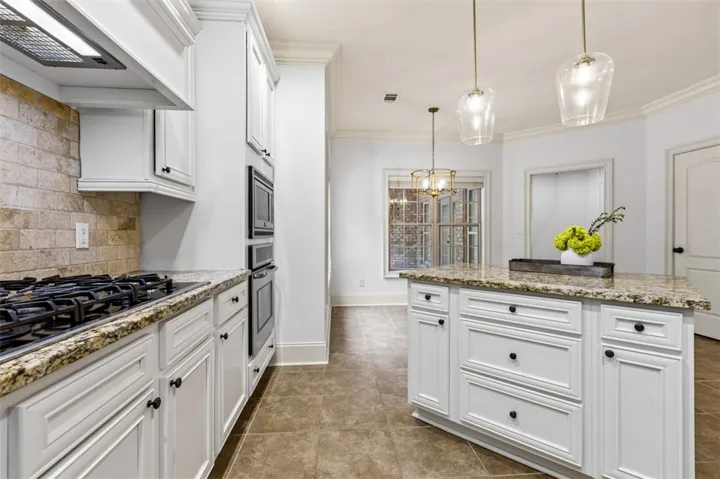 This bright kitchen features modern appliances, granite countertops, and an inviting island perfect for gatherings.