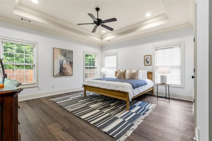 This tranquil bedroom offers comfort with classic architectural elements and rich flooring.
