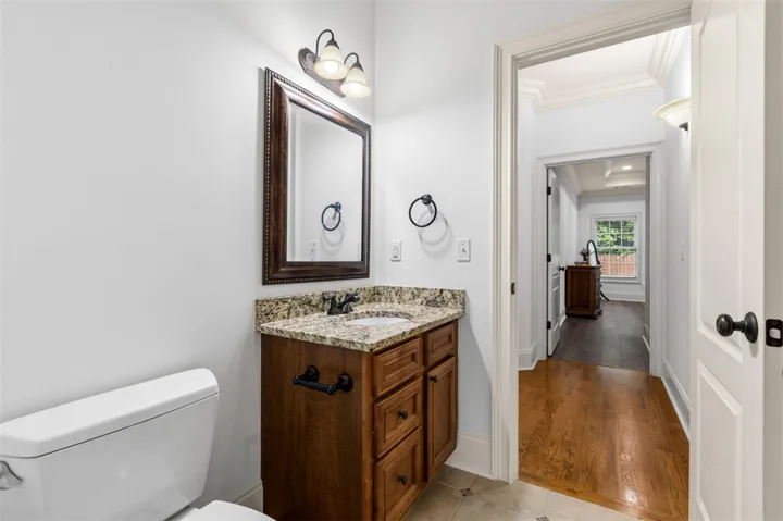 This bathroom features a sleek granite counter and a richly stained wood vanity.