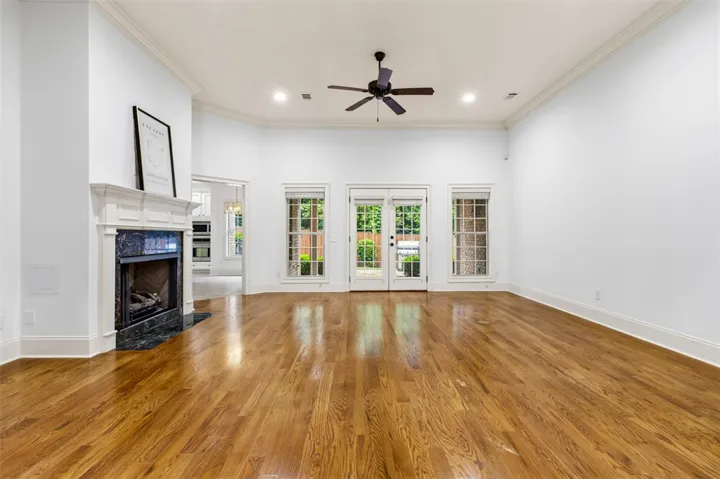 This bright living area features a classic fireplace, warm wood flooring, and abundant natural light.