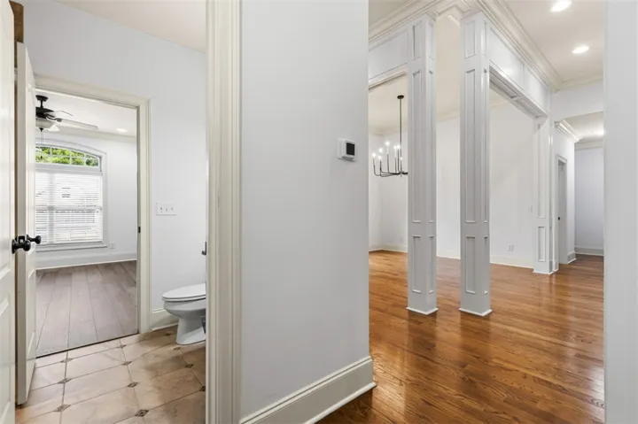 This interior hallway features warm wood flooring and elegant architectural columns.