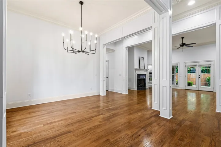 Elegant hardwood flooring flows through this expansive living area, leading to an inviting fireplace and outdoor access.