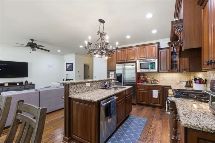 This kitchen features rich wooden cabinetry and granite countertops, creating a warm and inviting atmosphere.