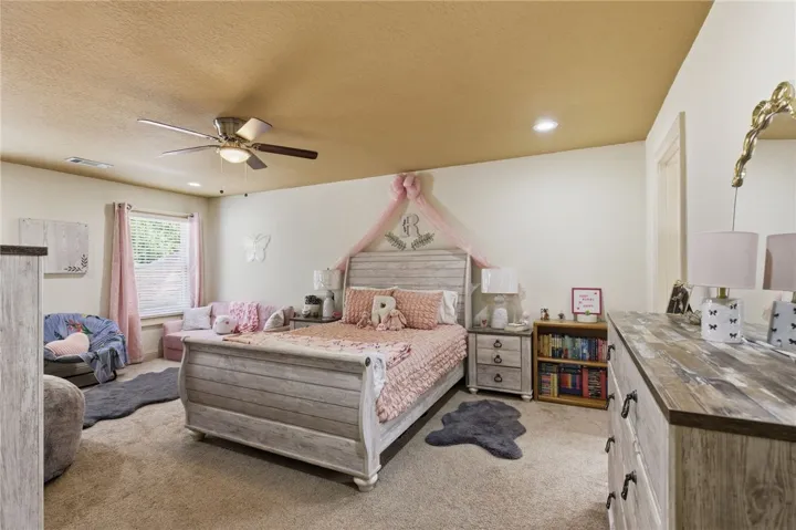 This spacious bedroom offers a bright and inviting atmosphere with ample natural light.