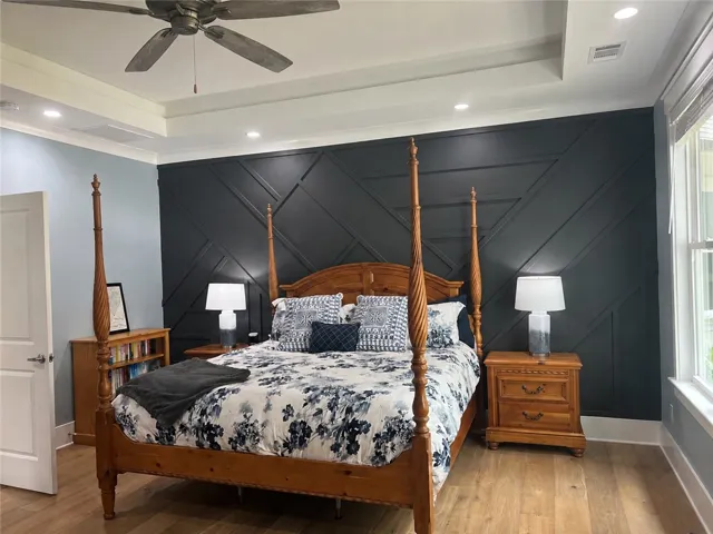 Hardwood floors and tray ceilings elevate this primary suite, offering a refined retreat.