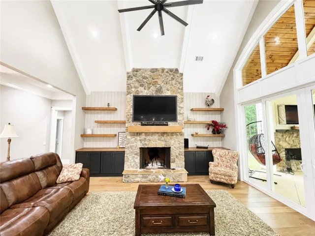 Stone fireplace and wood-paneled ceilings elevate this inviting living space.
