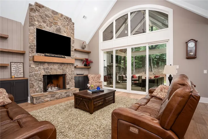 Vast living area with a stone fireplace and vaulted ceilings.