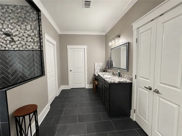 Granite counters and dual sinks elevate this primary bathroom's spacious design.