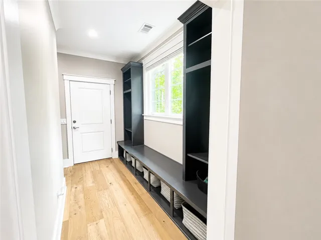 Functional back door entryway storage with built-in shelving offers both utility and design.