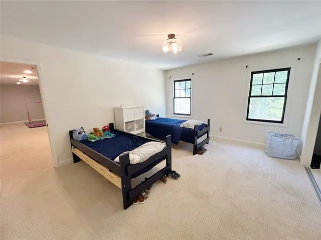 This bright and airy bedroom features ample natural light.