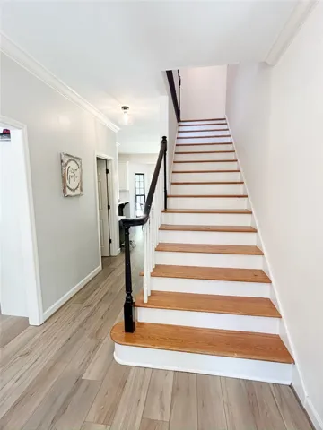 This inviting entryway features elegant wood flooring and a classic staircase.