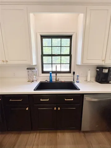 This modern kitchen features crisp white countertops and elegant dark cabinetry.
