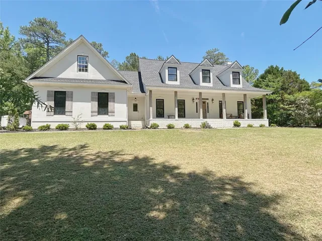 This classic white residence features a welcoming porch, perfect for enjoying peaceful outdoor moments.