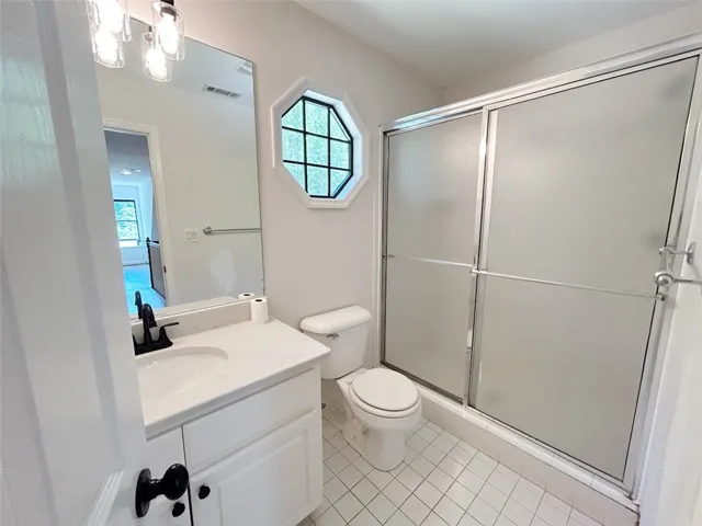 This bright bathroom features sleek tile flooring and a modern shower for daily convenience.
