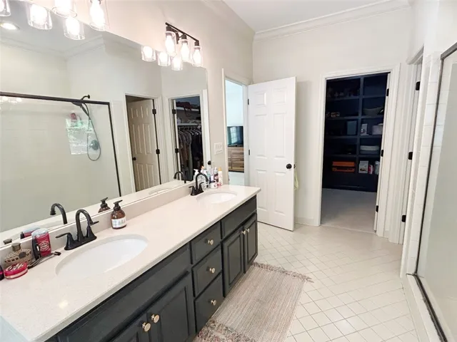 This spacious bathroom offers elegant fixtures and convenient walk-in closets.