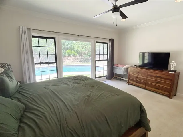 This peaceful bedroom offers direct views of the outdoor pool, creating a tranquil retreat.