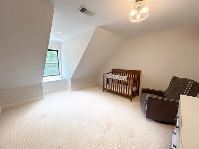 Bright and airy room featuring a charming window nook and plush carpeting.