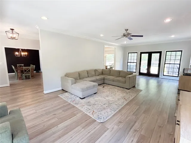 Bright and airy open-concept living area with gleaming wood flooring throughout.