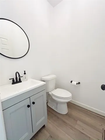 This bright bathroom features warm flooring and a modern vanity.