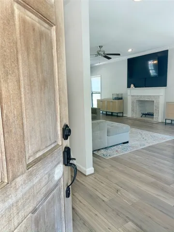 Enter into a bright living space featuring a fireplace and durable flooring.