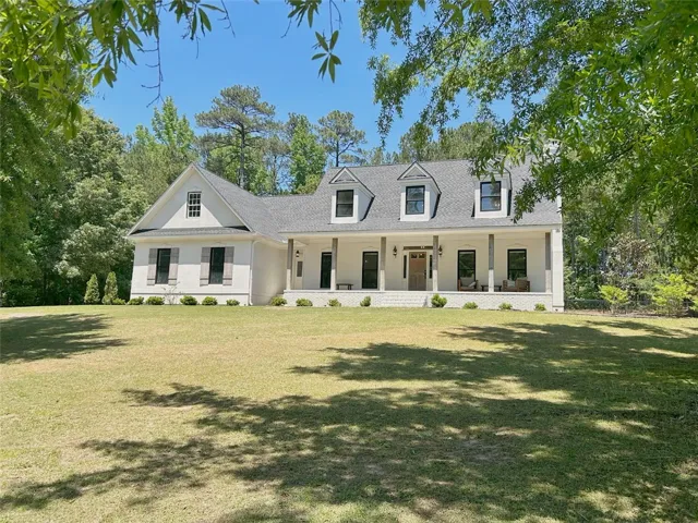 This elegant residence offers a classic facade with a welcoming front porch, perfect for outdoor living.