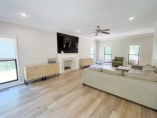 This bright living space features elegant flooring and a cozy fireplace, perfect for gatherings.