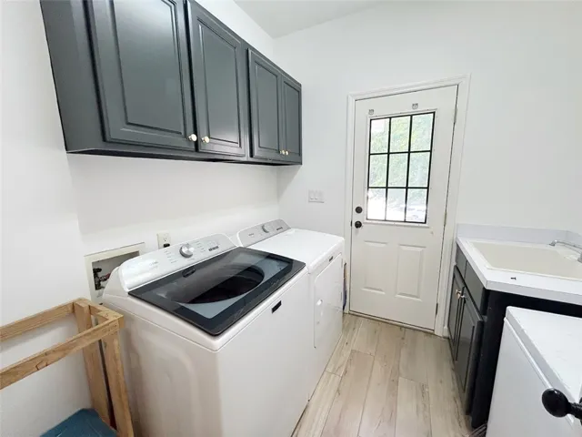 This functional laundry area features ample storage and a convenient utility sink.