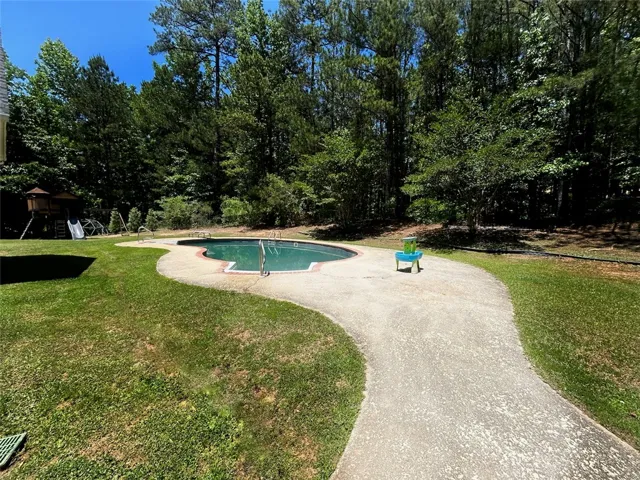 This expansive yard features a private in-ground pool, perfect for outdoor recreation and relaxation.