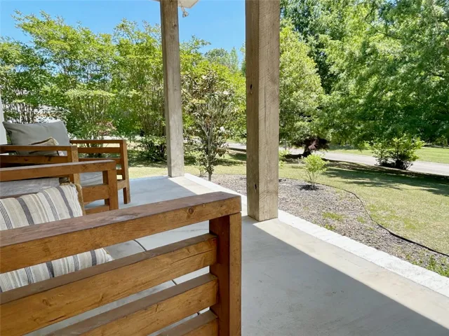 Enjoy leisurely afternoons on this inviting outdoor porch, seamlessly blending comfort with natural surroundings.