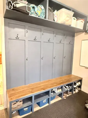 Organized space in the garage features built-in storage, a seating bench, and convenient hooks for everyday essentials.