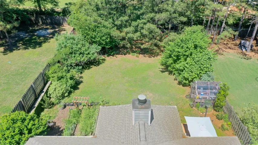 Backyard offers privacy with mature trees and a fenced perimeter.