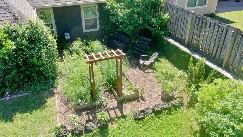 This lush backyard features a beautiful garden, perfect for outdoor living and entertaining.