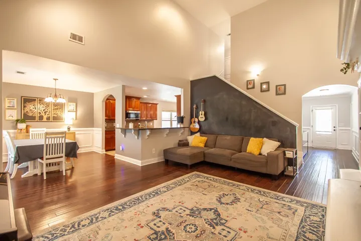 This inviting space features an open layout with rich hardwood flooring and a functional kitchen pass-through.