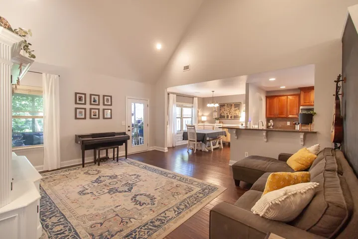 This inviting interior features an open layout, connecting living, dining, and kitchen areas with hardwood floors.