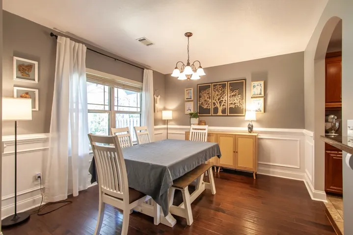 This inviting dining room offers rich wood flooring and classic wainscoting.