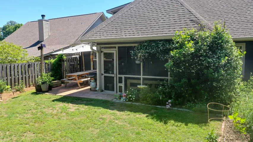 This private backyard oasis features a screened-in porch and patio area perfect for outdoor living.