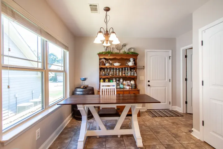 This bright dining area features ample natural light and a charming overhead fixture.