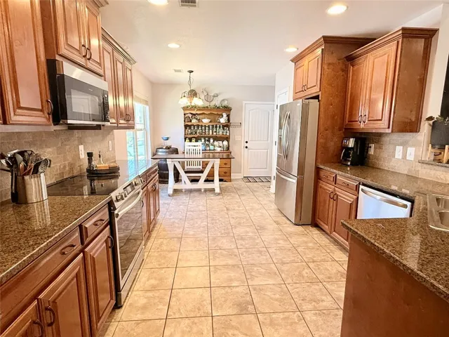 The kitchen features ample cabinetry and a tiled floor, perfect for daily living and entertaining.