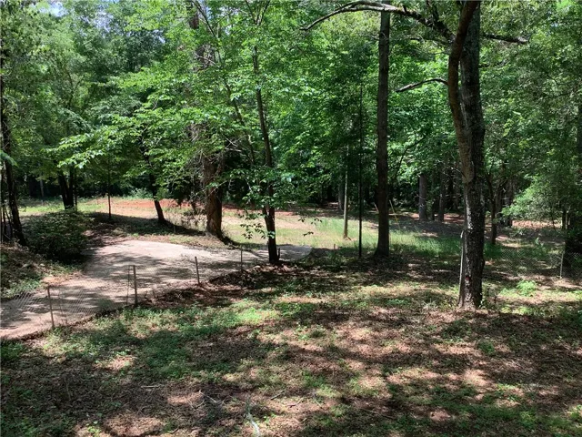 A tranquil wooded lot offers a peaceful retreat for your future home.