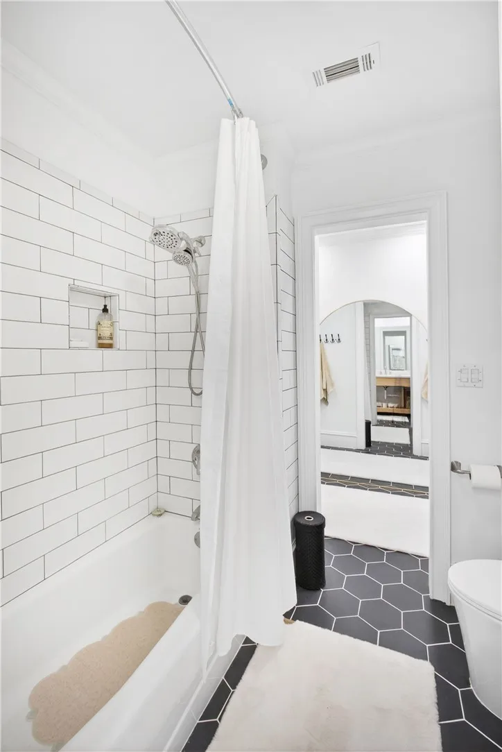 This sleek bathroom features classic subway tile and striking hexagonal floor tiles.