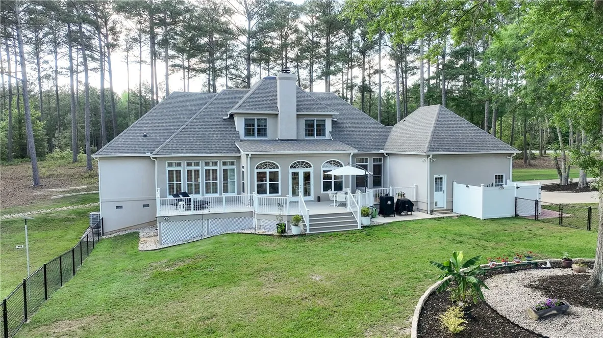 This spacious estate features a large deck overlooking a private, wooded backyard.