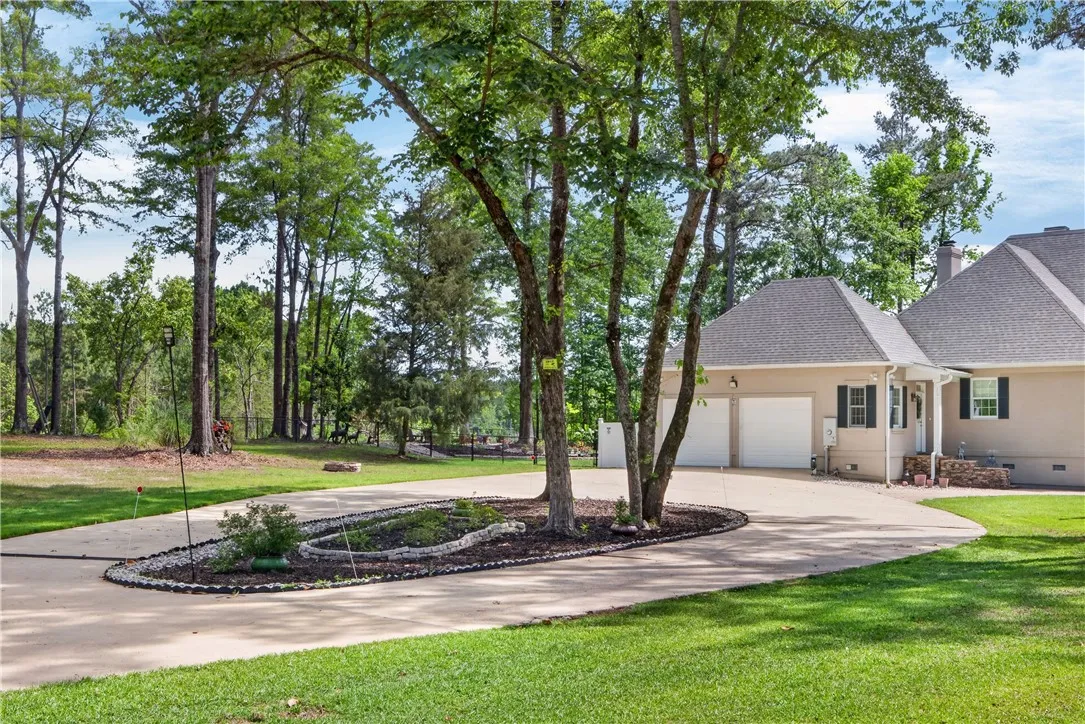 This spacious property boasts a two-car garage and an expansive, lush lawn.