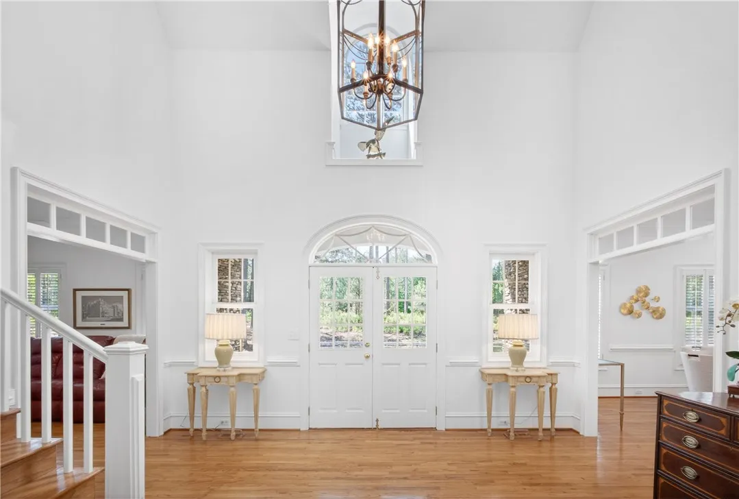 This bright and airy foyer welcomes with high ceilings and rich hardwood floors.