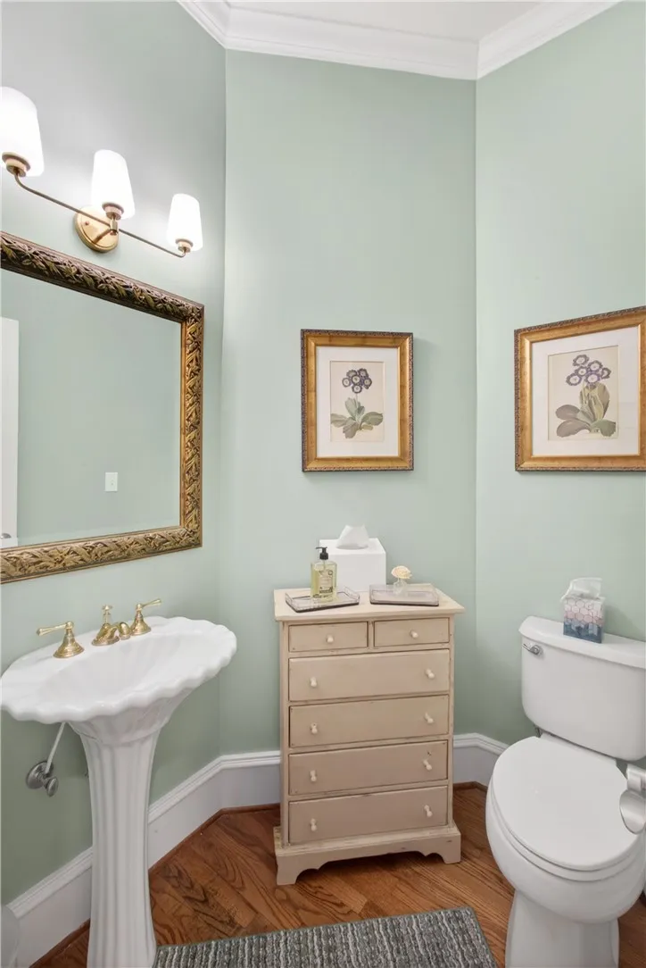 This serene bathroom offers classic elegance and hardwood flooring, perfect for daily routines.