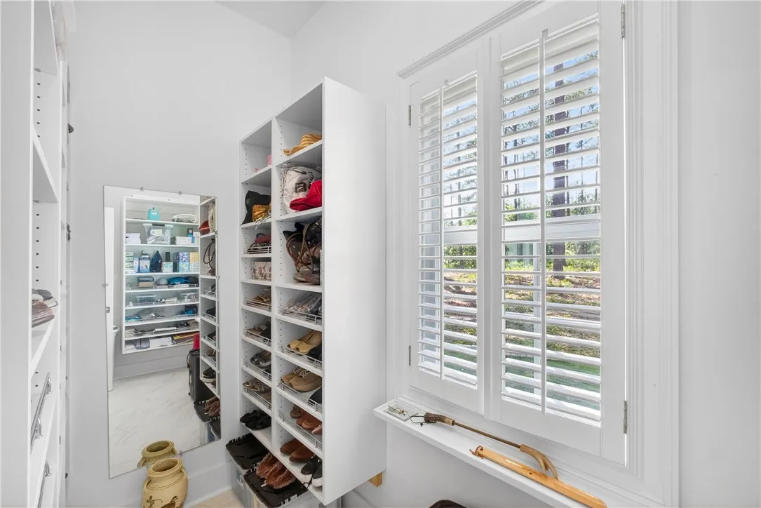 This spacious walk-in closet offers extensive built-in shelving and natural light.